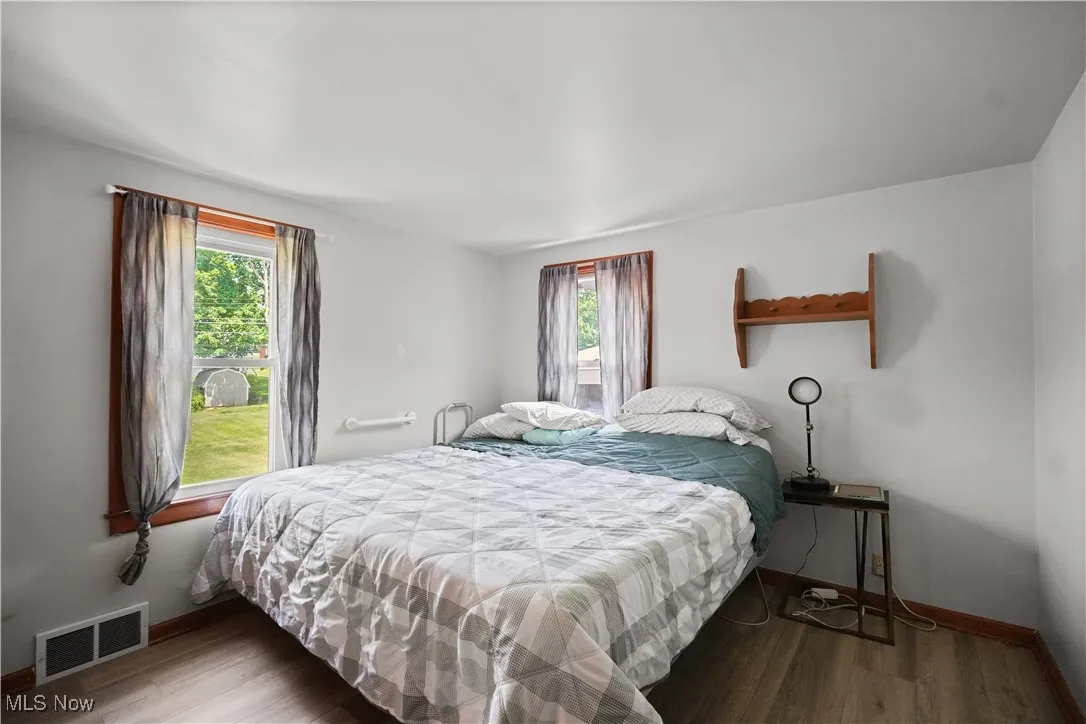 Bedroom with multiple windows and wood finished floors
