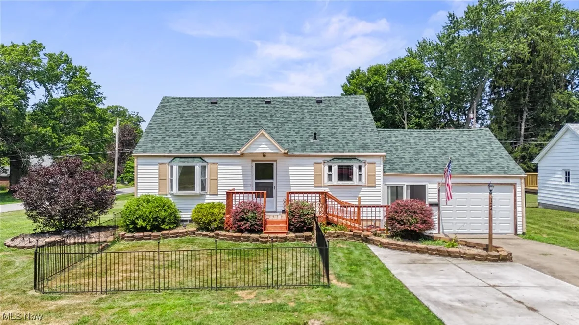 View of front of house featuring a shingled roof, driveway, and a garage
