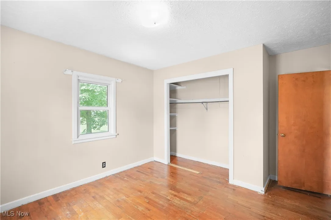 Unfurnished bedroom featuring light wood-style floors, a closet, and a textured ceiling