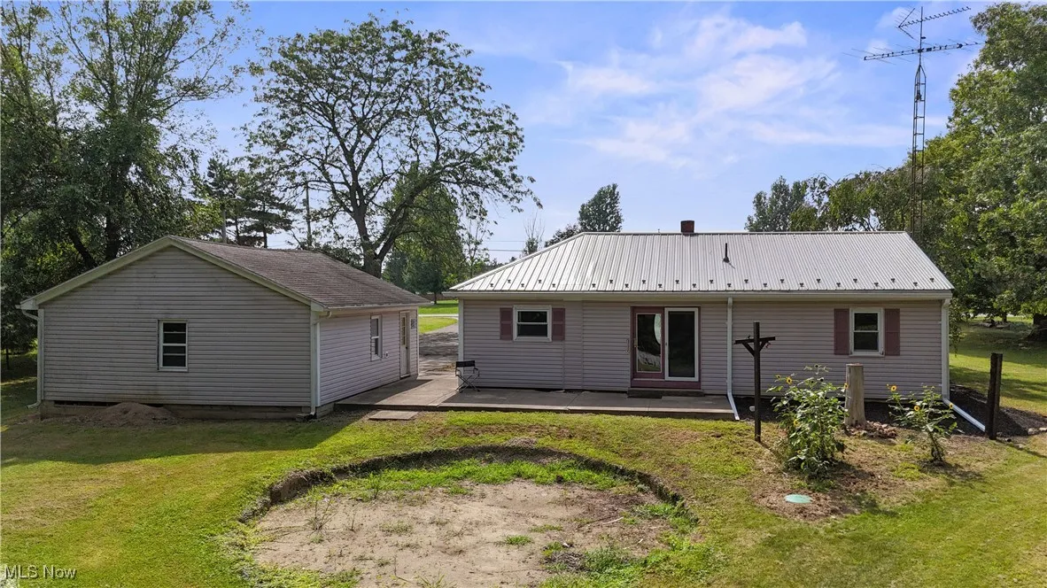 Back of house with a yard, a wooden deck, and a metal roof