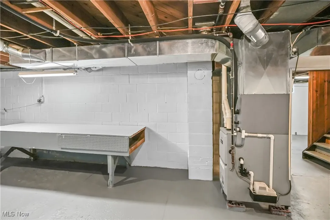 Unfinished below grade area featuring heating unit