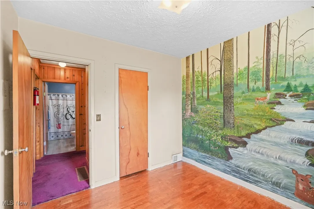 Unfurnished bedroom featuring wood finished floors and a textured ceiling
