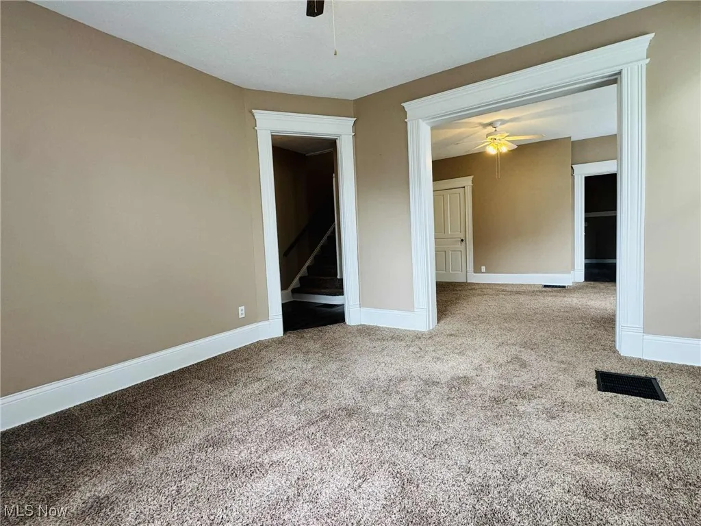 Spare room with ceiling fan and carpet