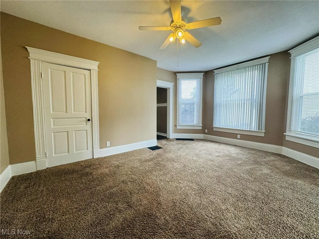 Spare room featuring carpet floors and ceiling fan