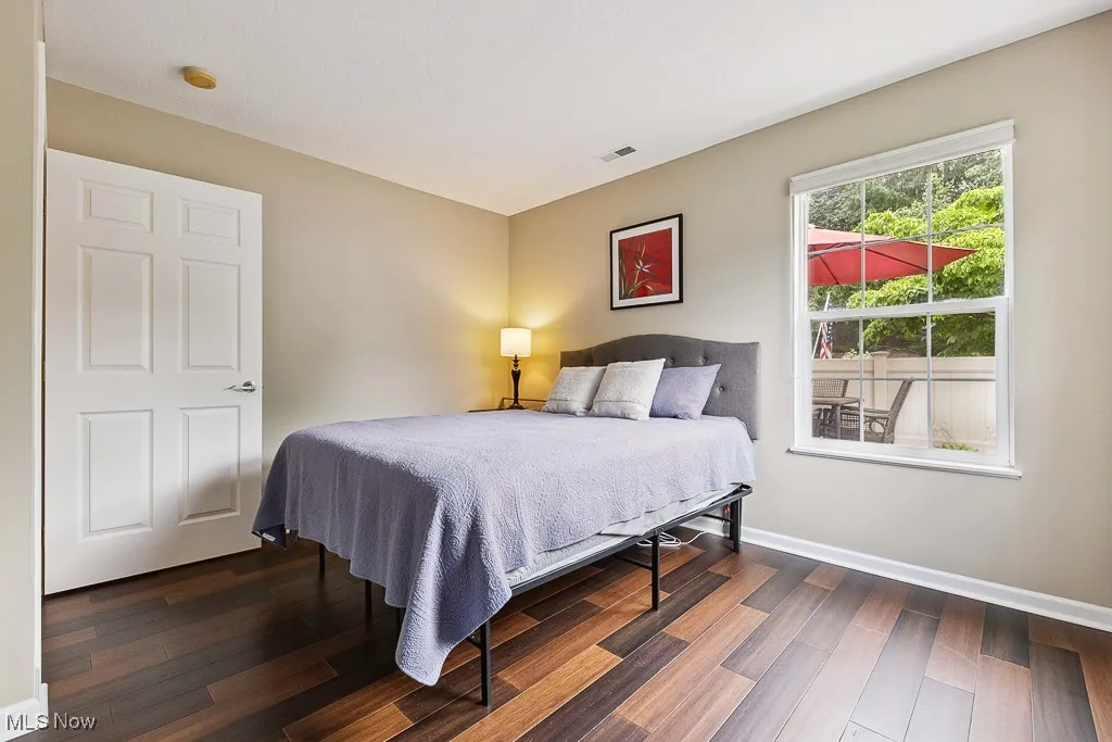 Bedroom with dark wood-style floors and baseboards