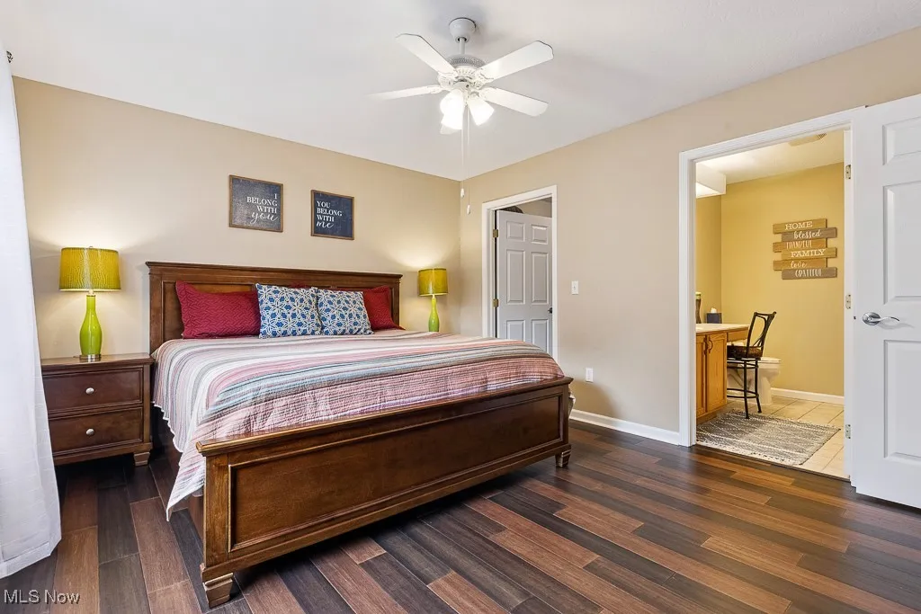 Bedroom featuring wood finished floors, ensuite bathroom, and ceiling fan