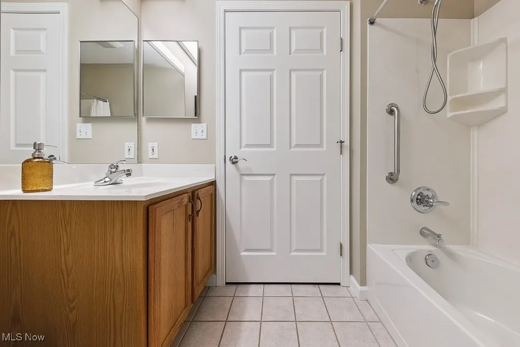 Full bath with tile patterned flooring,  shower combination, and vanity
