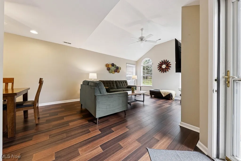 Living room with ceiling fan, dark wood-style flooring, recessed lighting, and vaulted ceiling