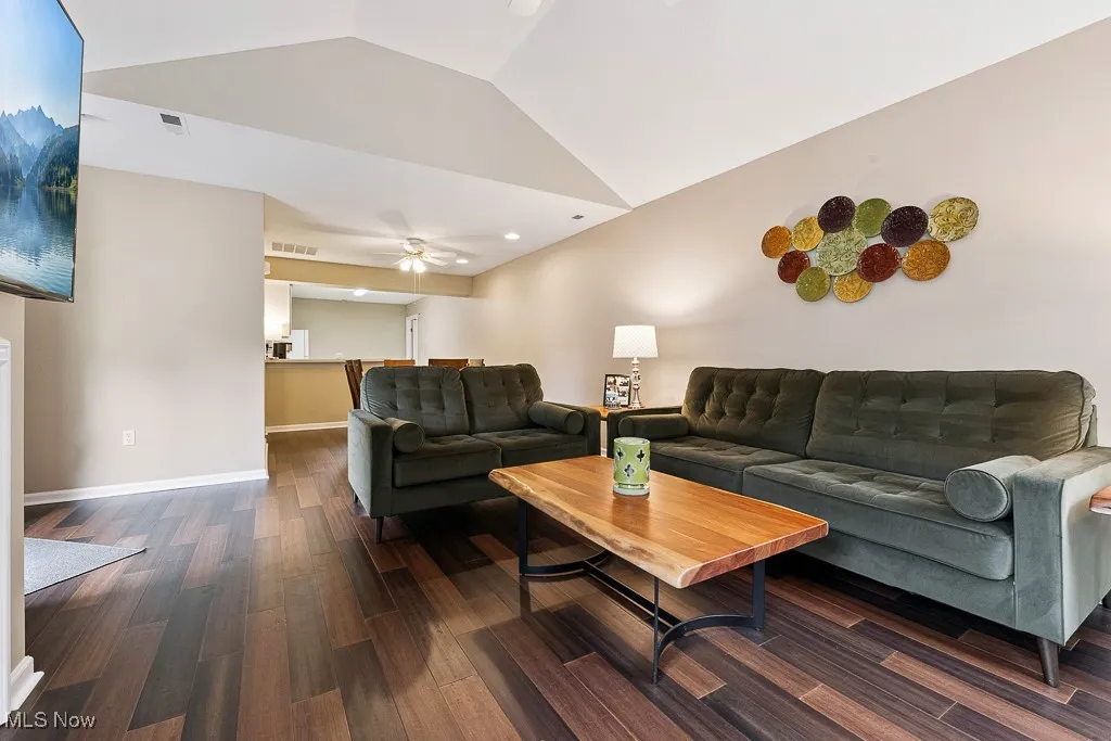 Living area with vaulted ceiling, dark wood finished floors, ceiling fan, and recessed lighting