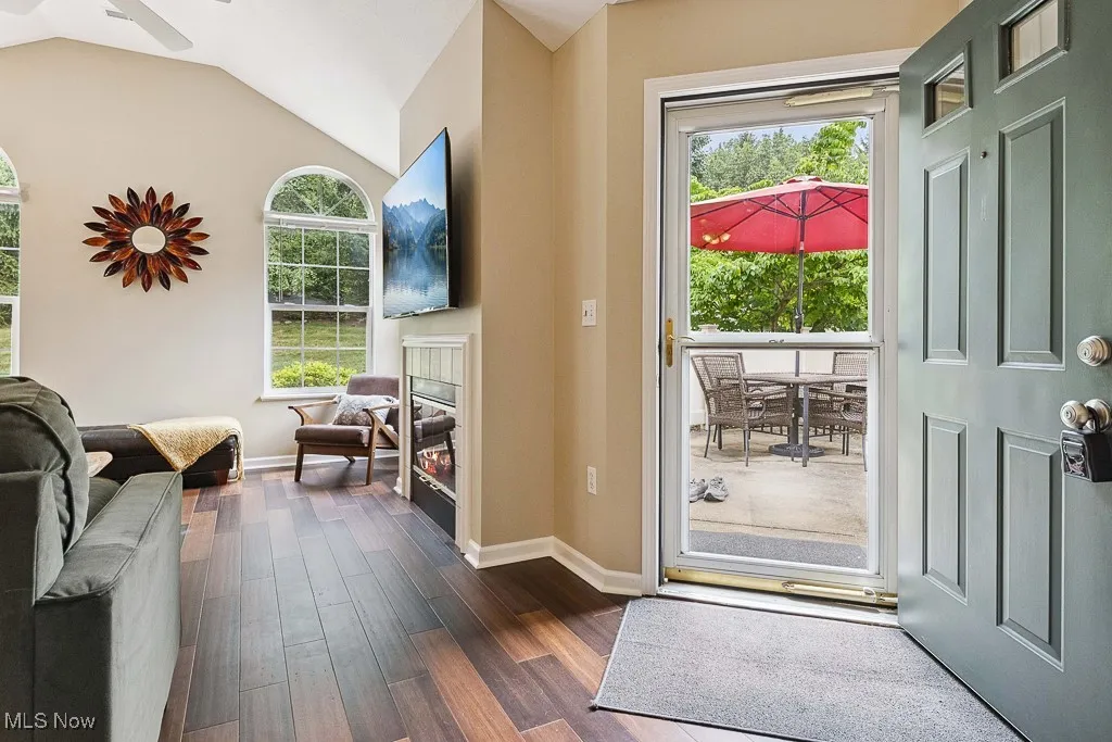 Entryway featuring dark wood-type flooring, plenty of natural light, lofted ceiling, and ceiling fan