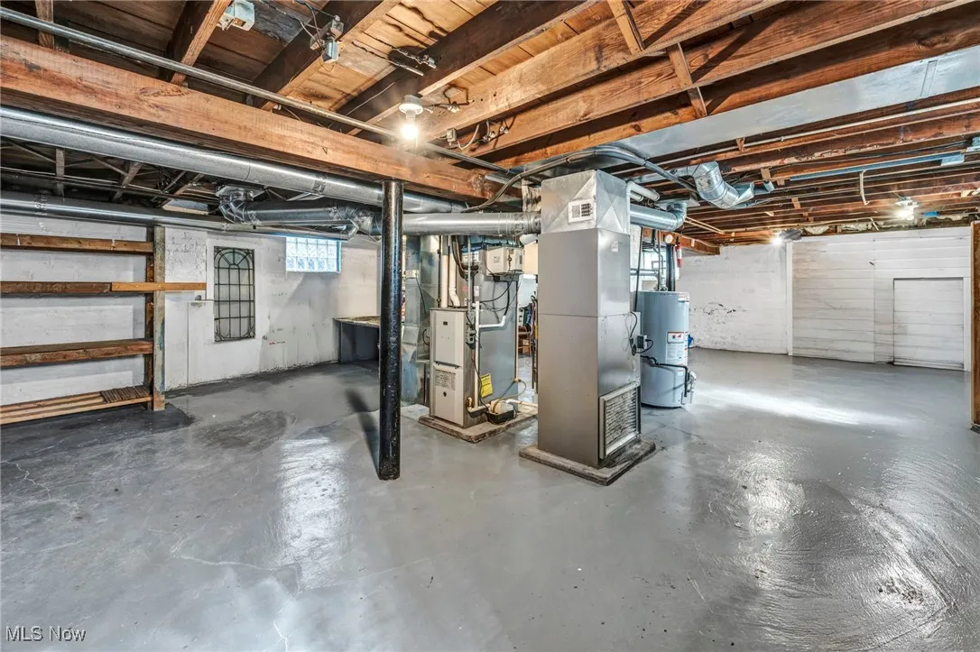 Basement featuring heating unit and water heater