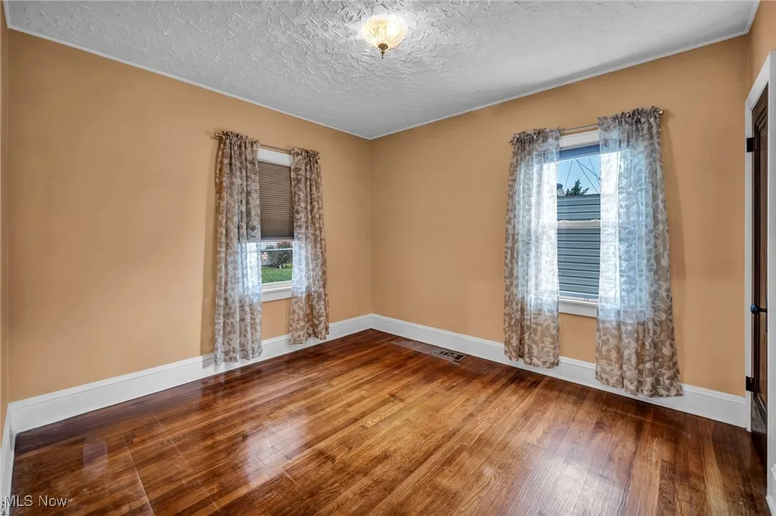 Unfurnished room featuring wood finished floors and a textured ceiling