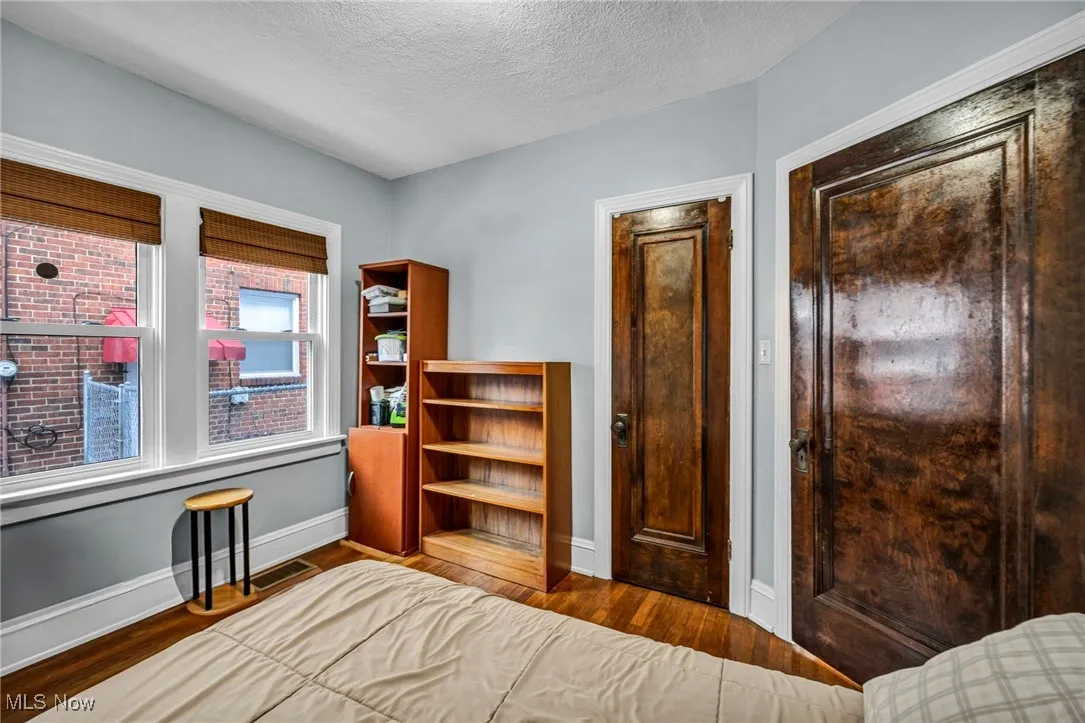 Bedroom with wood finished floors and a textured ceiling