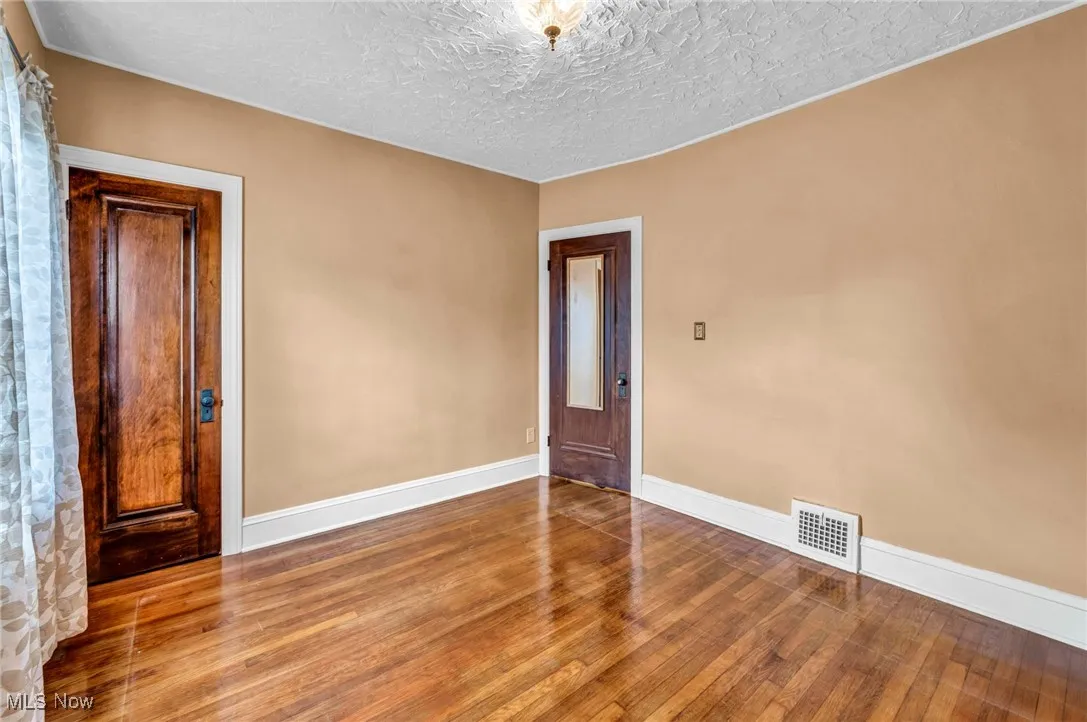 Spare room featuring wood finished floors and a textured ceiling