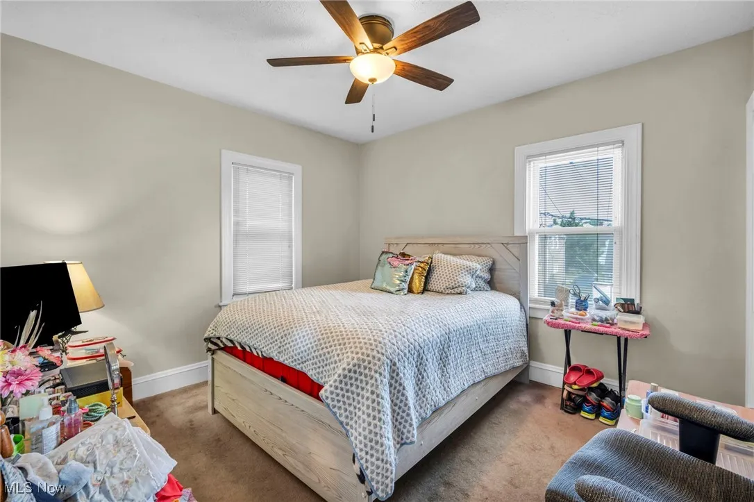 Carpeted bedroom featuring baseboards and a ceiling fan