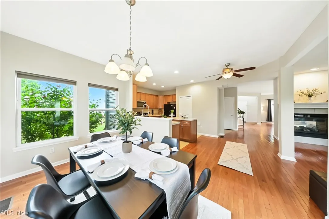 Dining area with light wood-type flooring, a chandelier, a ceiling fan, and recessed lighting