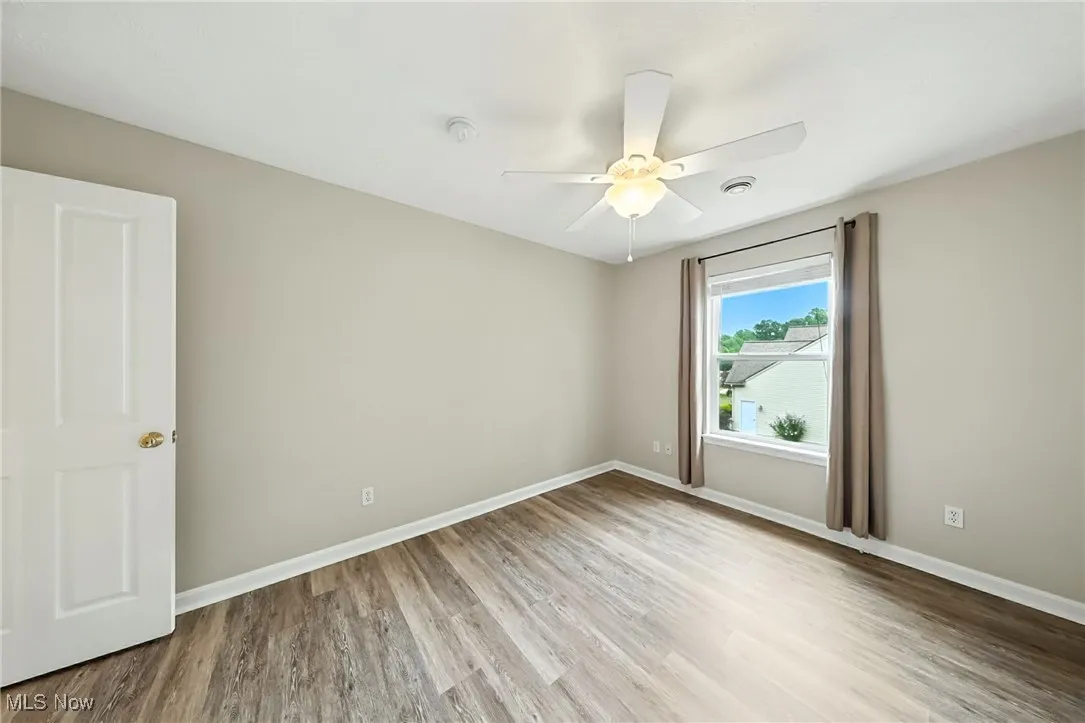 Spare room with wood finished floors and ceiling fan