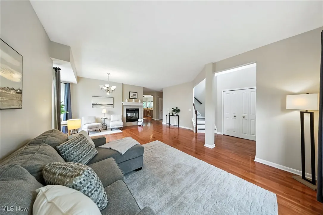 Living room featuring stairway, wood finished floors, and a chandelier