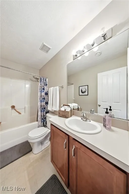 Bathroom featuring shower / tub combo with curtain and vanity