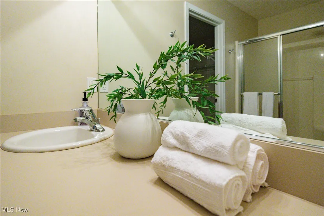 Full bathroom featuring an enclosed shower and vanity
