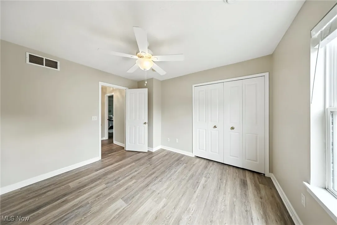 Unfurnished bedroom featuring wood finished floors, a closet, and ceiling fan