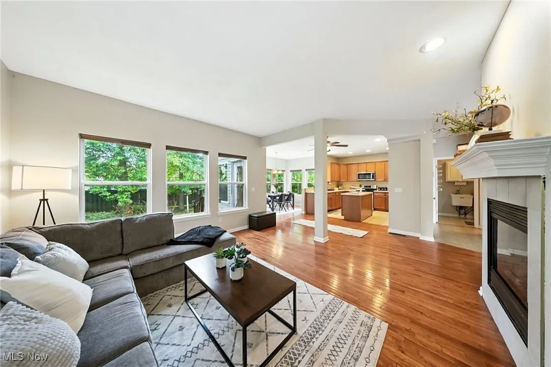 Living area with light wood finished floors, a fireplace, recessed lighting, and a ceiling fan