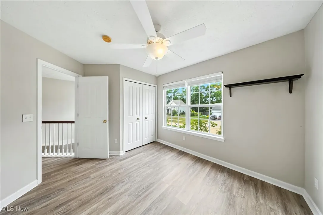 Unfurnished bedroom featuring wood finished floors, a closet, and ceiling fan