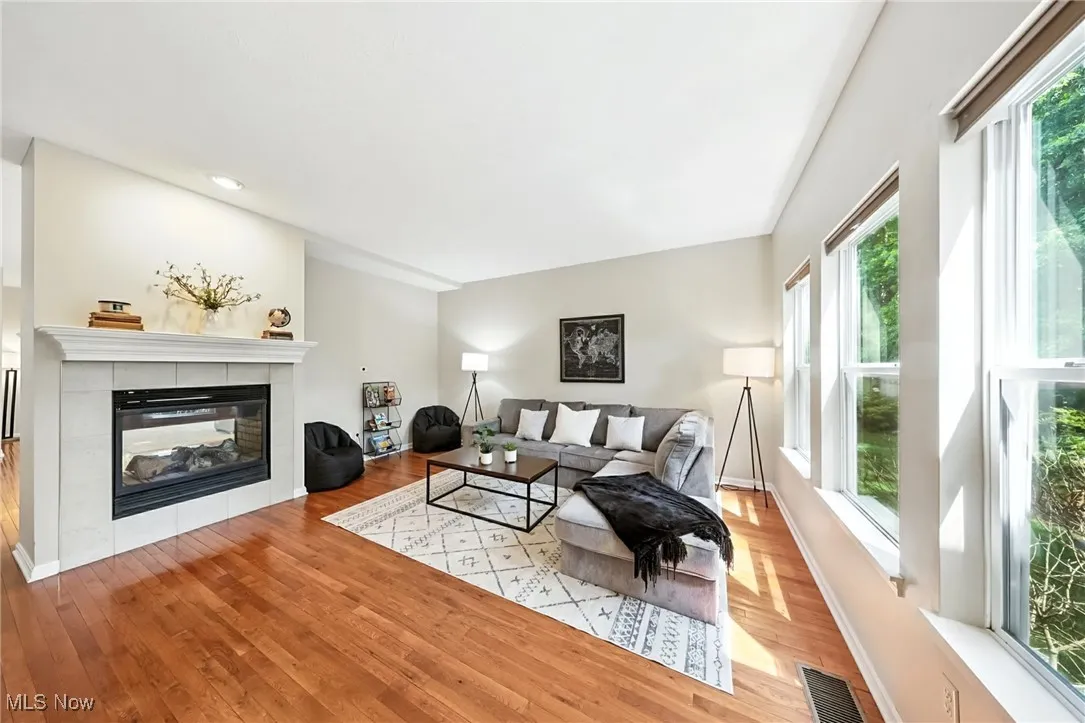 Living room with wood finished floors and a tiled fireplace