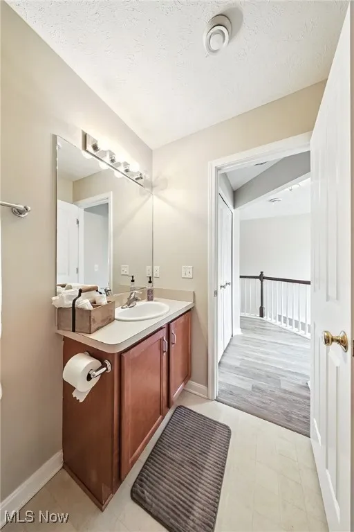 Bathroom with vanity and a textured ceiling