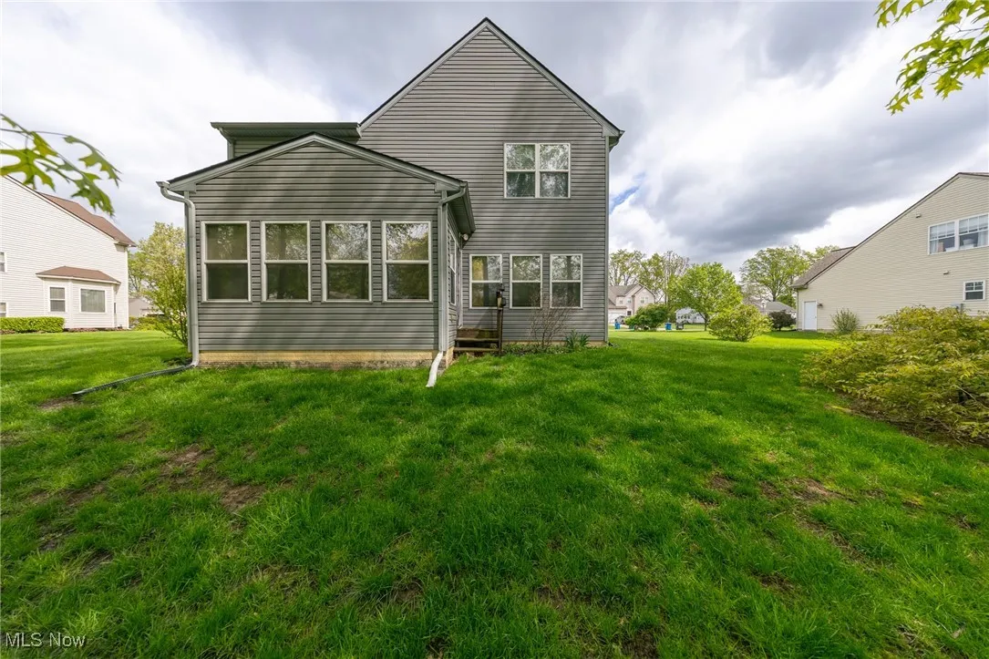 Back of property with a lawn