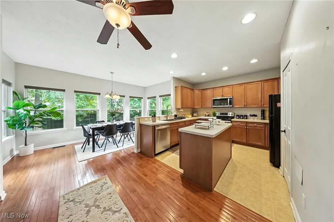Kitchen with appliances with stainless steel finishes, light countertops, light wood-style floors, ceiling fan, and recessed lighting