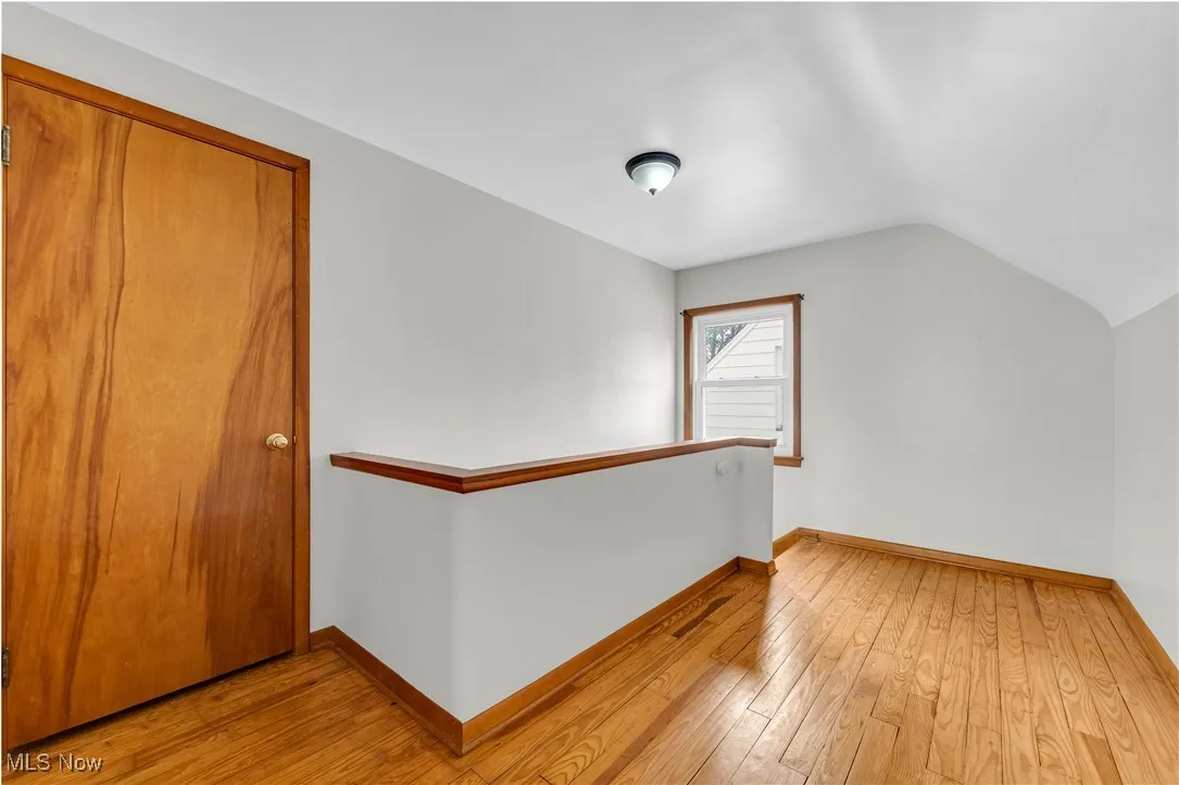 Bonus room featuring light wood-style floors and lofted ceiling