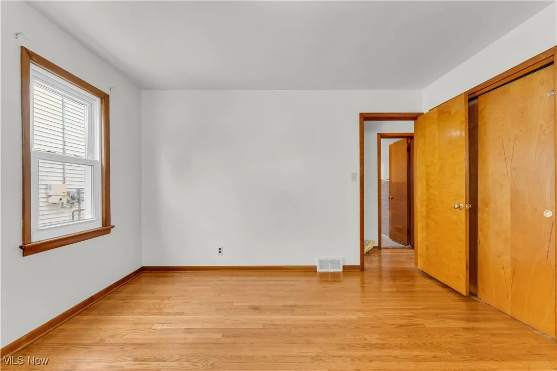 Unfurnished room with light wood finished floors and baseboards