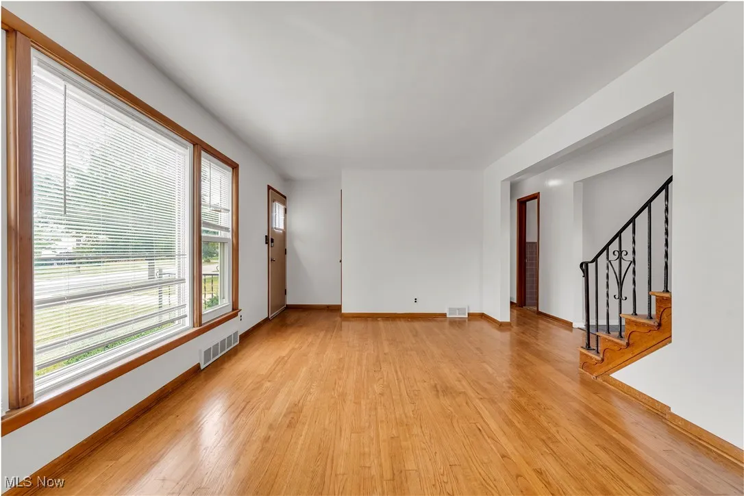 Spare room with light wood-style floors and stairway