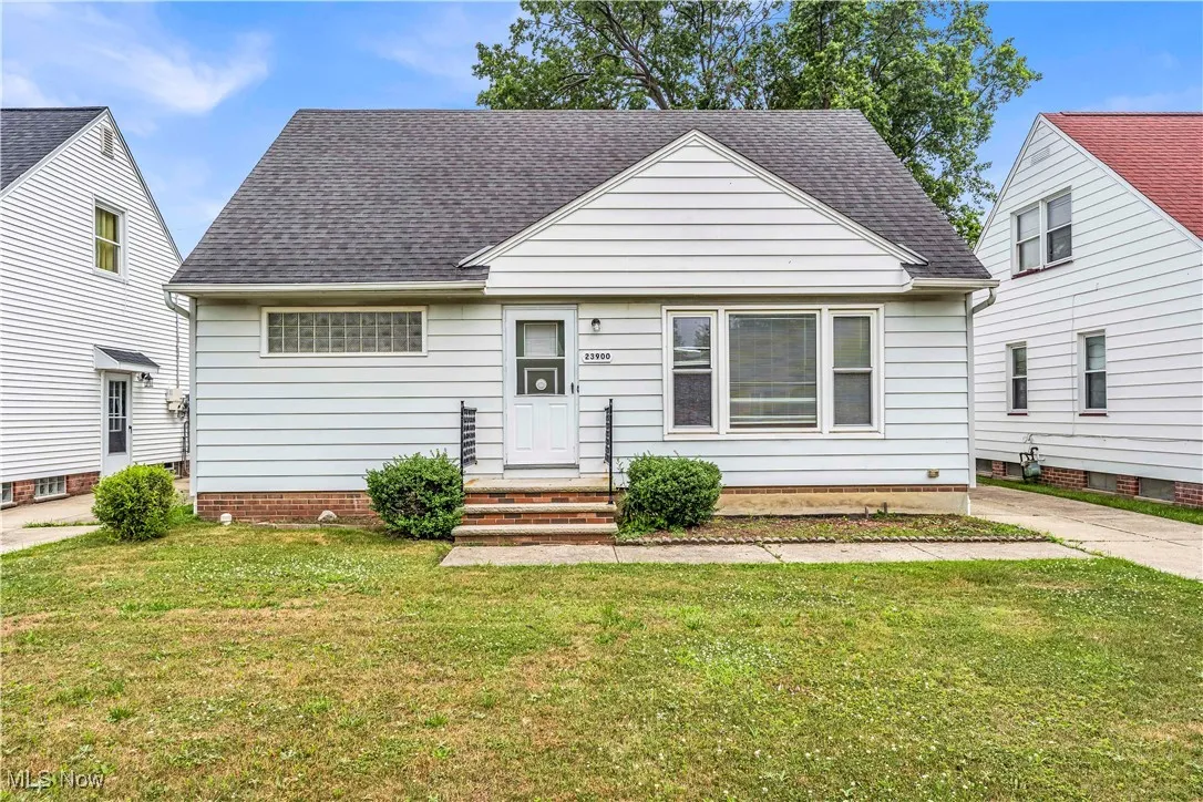 Bungalow with a shingled roof and a front lawn
