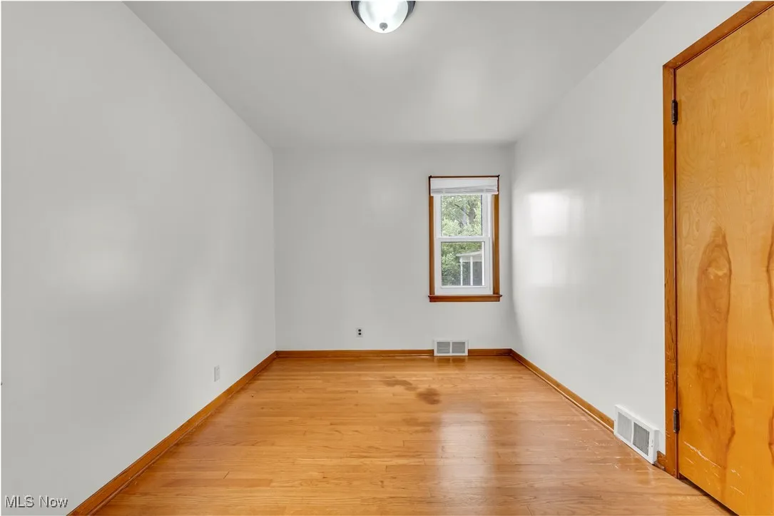 Spare room featuring light wood-style floors and baseboards