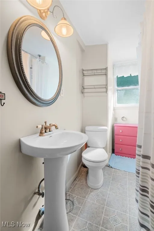 Bathroom with toilet and baseboards