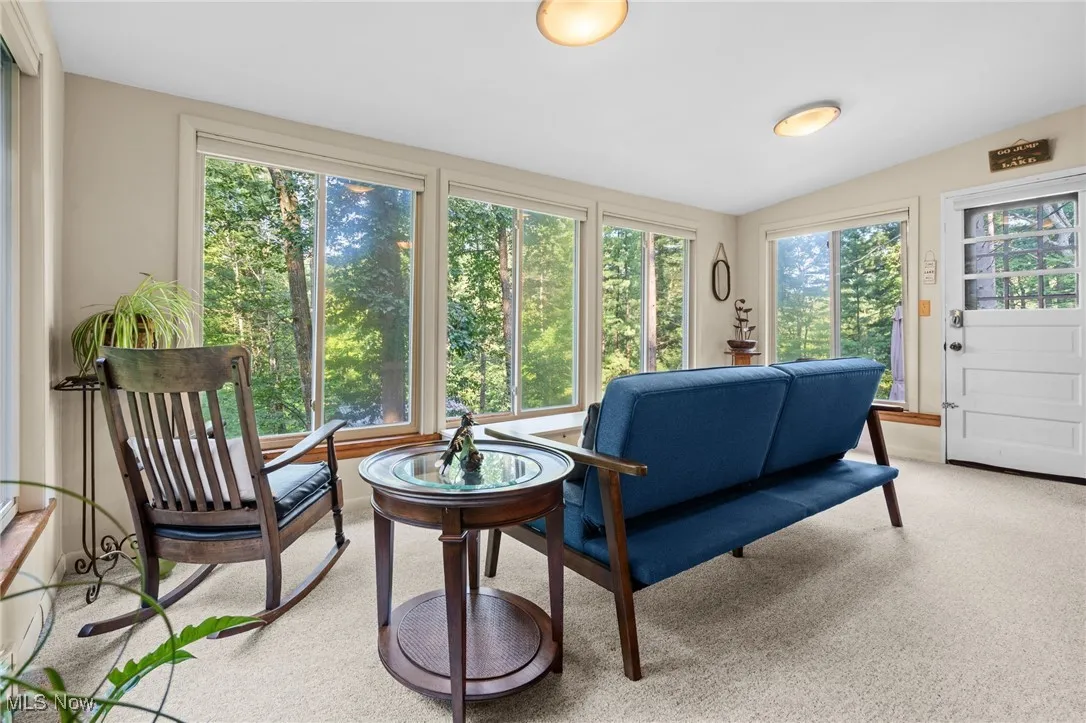 Living area with light carpet and vaulted ceiling