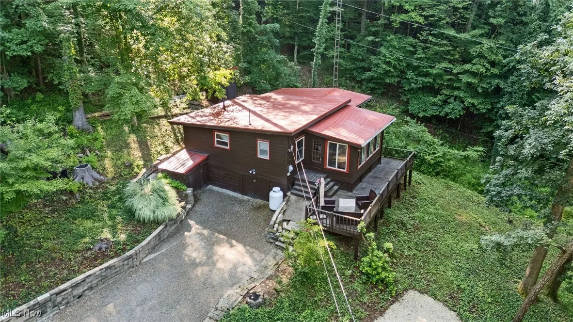 Aerial view of property and surrounding area with a heavily wooded area