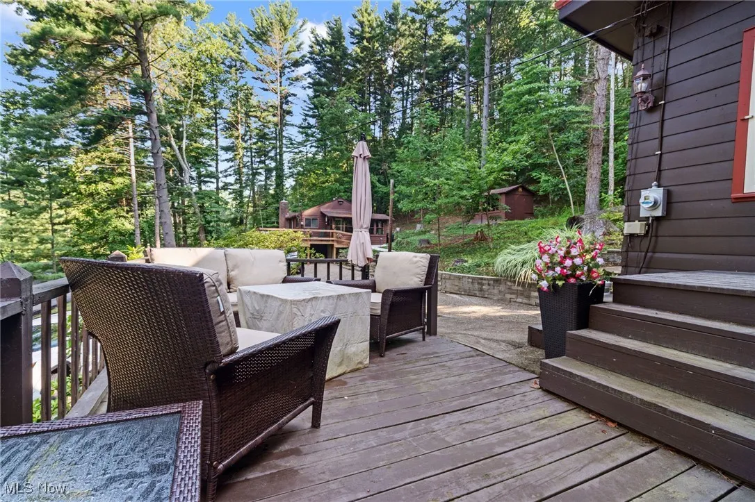 Wooden deck featuring an outdoor living space and view of wooded area
