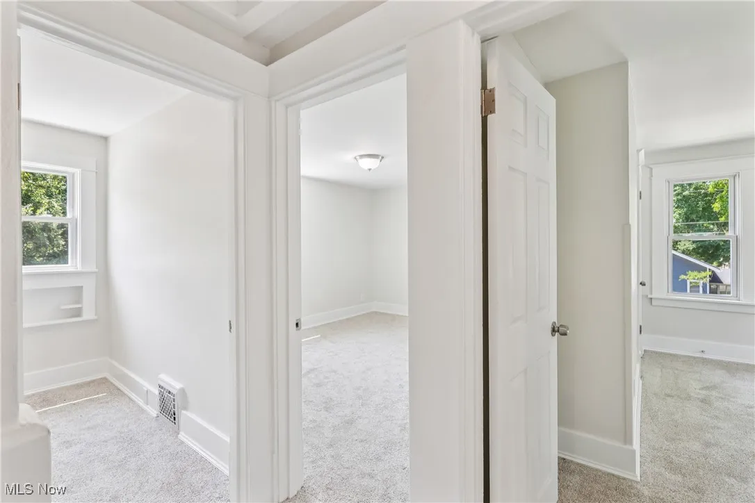 Hallway looking into bedrooms with carpet flooring