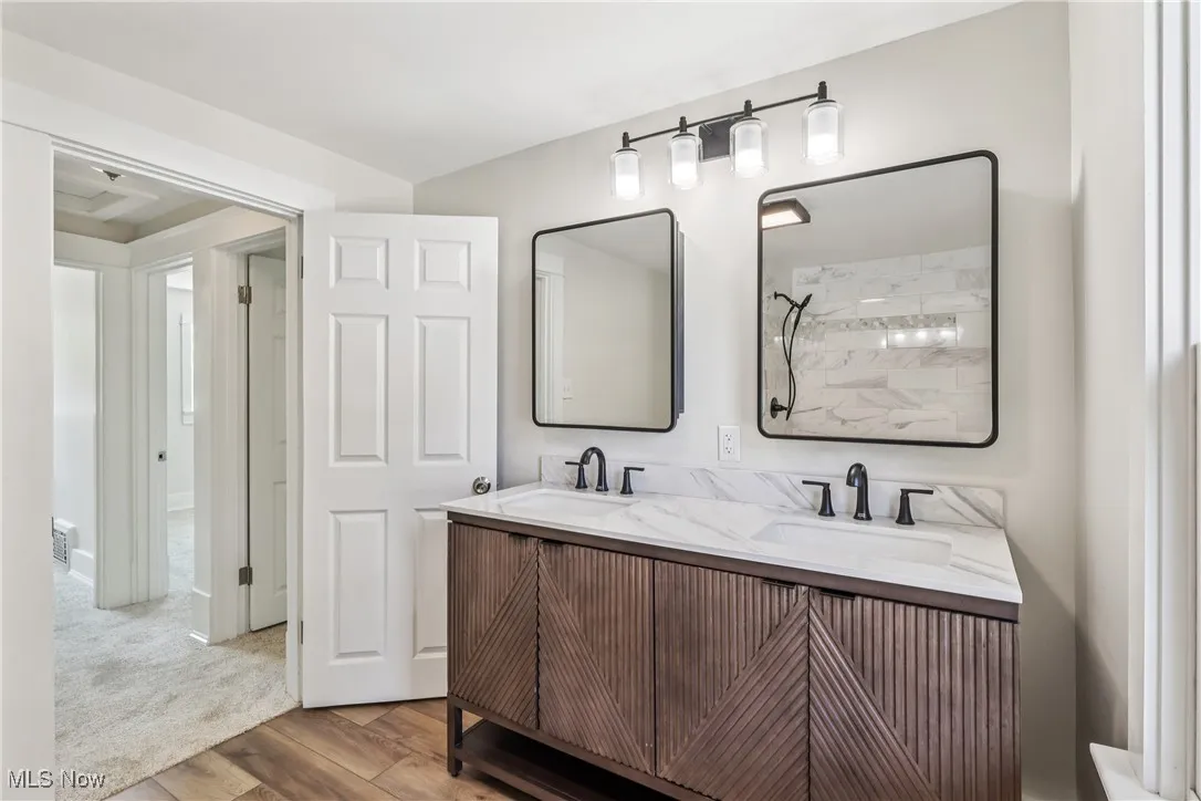 Full bathroom with duel sinks and vanity combination, special lighting and LVT flooring