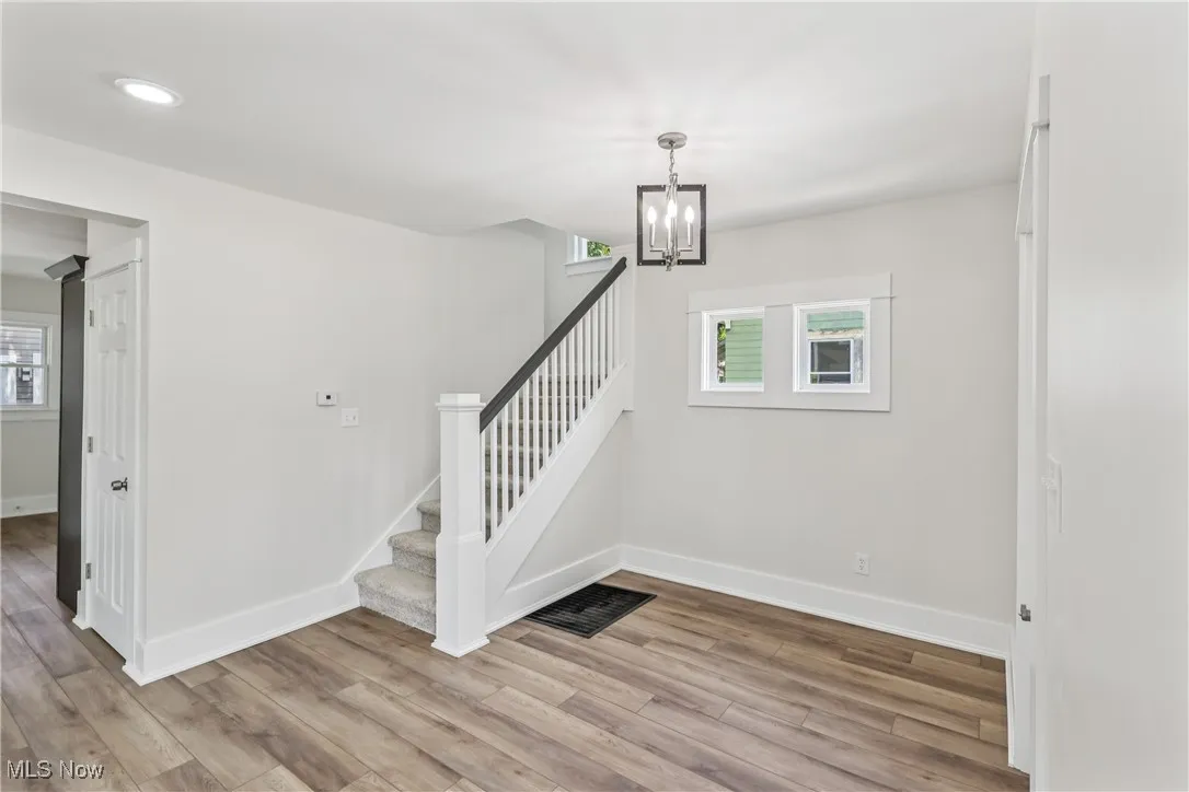 Entrance foyer featuring a healthy amount of natural light, stairway to second level, a chandelier and LVT flooring