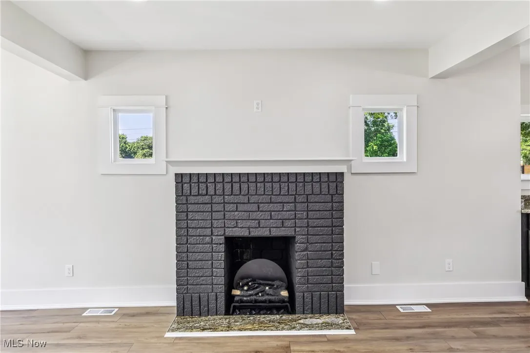 Living room with electric fireplace, duel windows on each side, and LVT flooring