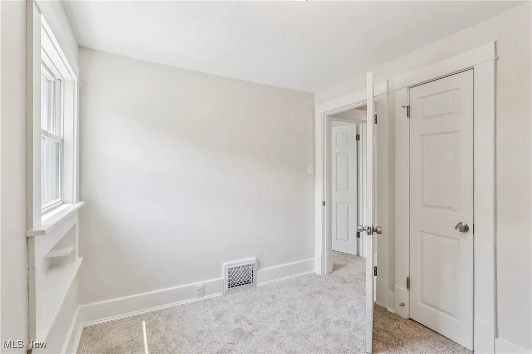 Another view of the bedroom with a closet and carpet flooring