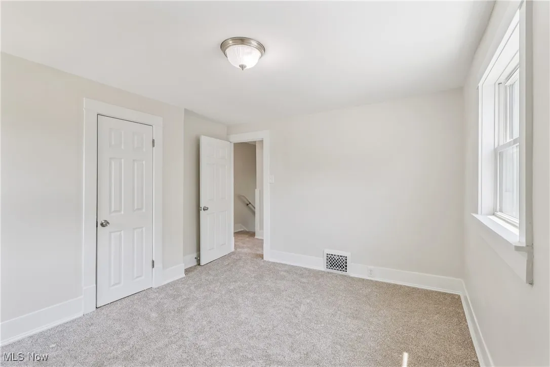 Another view of the bedroom with a closet and carpet flooring