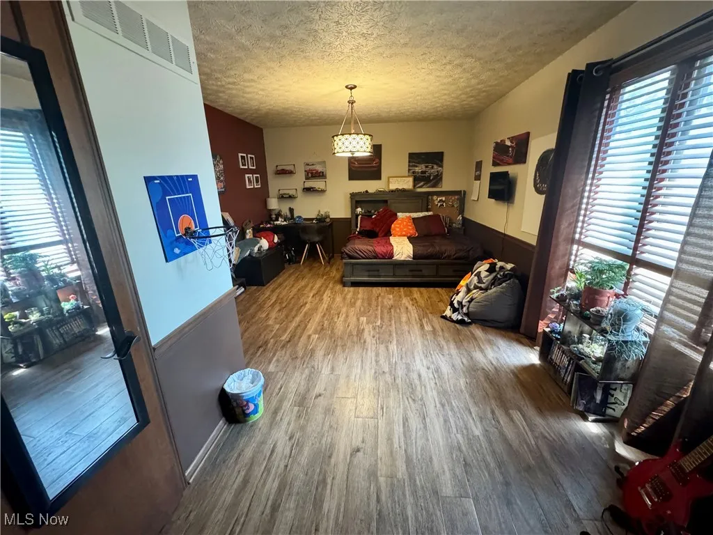 Living area with wood finished floors, plenty of natural light, and a textured ceiling