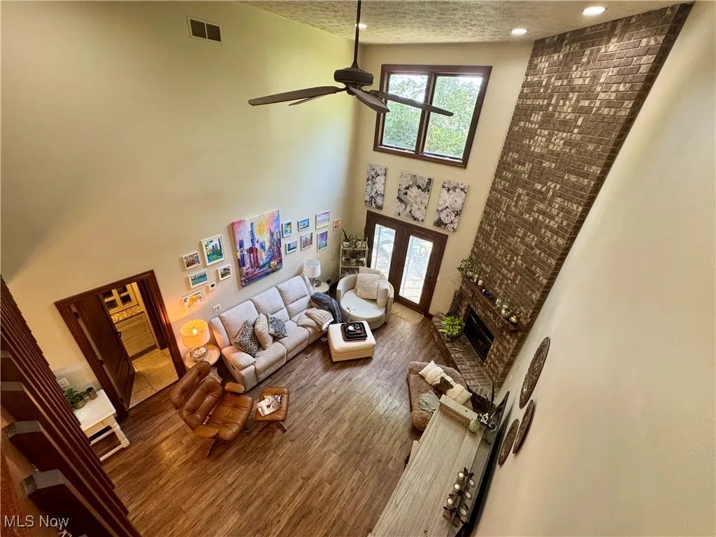 Living room featuring ceiling fan, wood finished floors, french doors, a textured ceiling, and recessed lighting