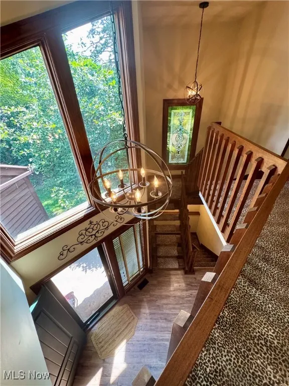 Staircase featuring a chandelier and wood finished floors