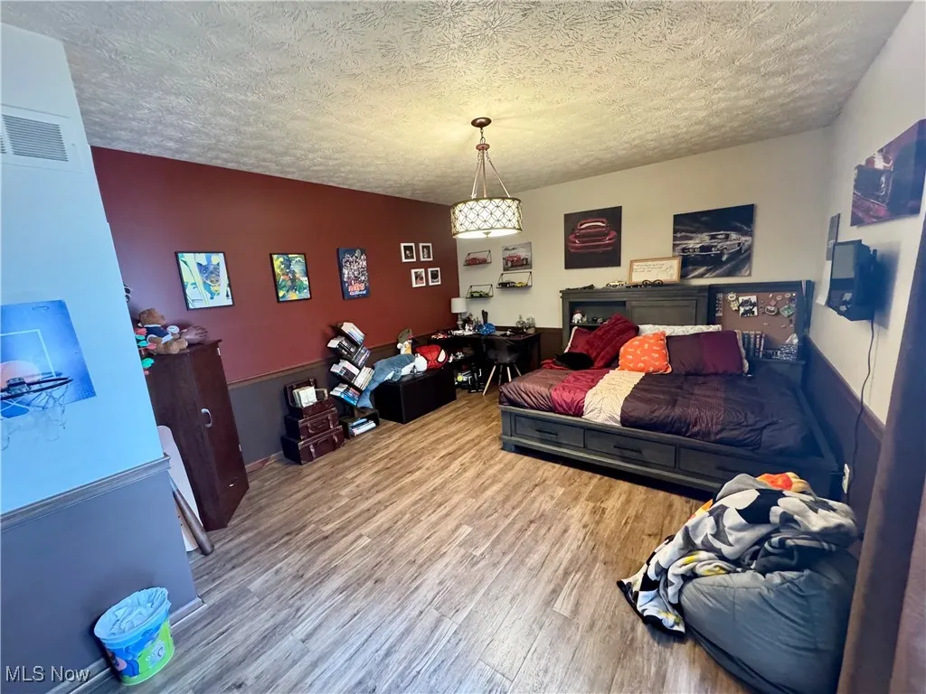 Bedroom featuring wood finished floors and a textured ceiling
